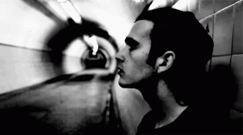 a black and white photo of a man in a tunnel .