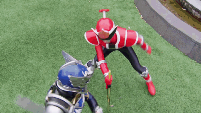 a red superhero is kicking a blue superhero in the face