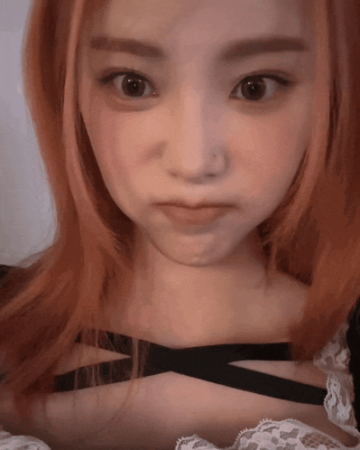 a close up of a woman 's face with red hair and brown eyes
