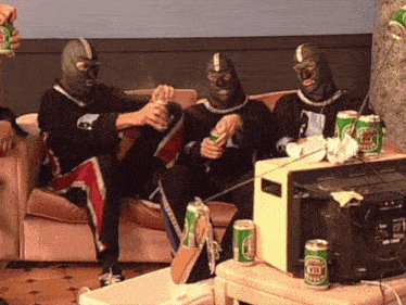 a group of people wearing masks are sitting on a couch drinking heineken beer
