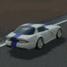 a white sports car with blue stripes is driving down the road .
