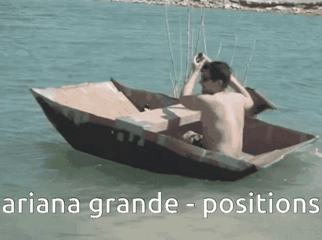 a man is sitting in a cardboard boat with the words ariana grande positions above him
