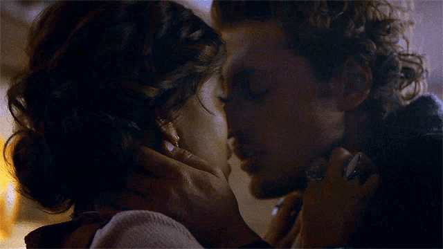 a man and a woman are kissing with their eyes closed