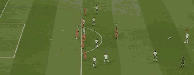 a group of soccer players are playing on a field with a yellow cone in the middle of the field
