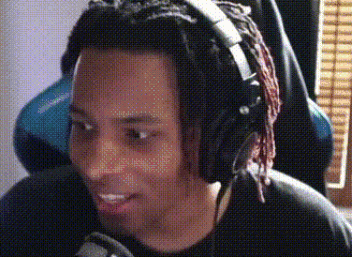 a man with dreadlocks is wearing headphones and smiling at the camera .