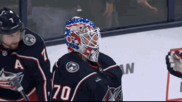 a hockey player wearing a helmet with the number 70 on it