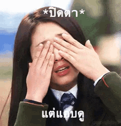 a woman is covering her eyes with her hands in a foreign language
