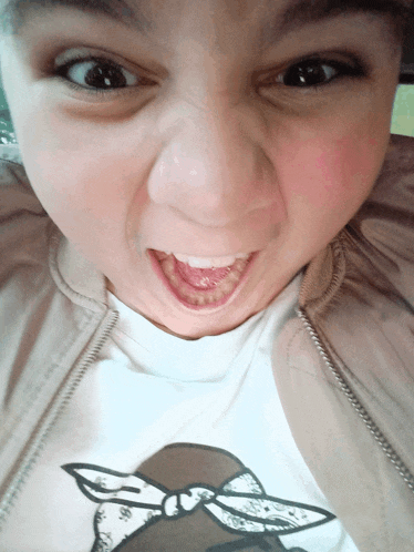 a close up of a girl 's face with her mouth wide open