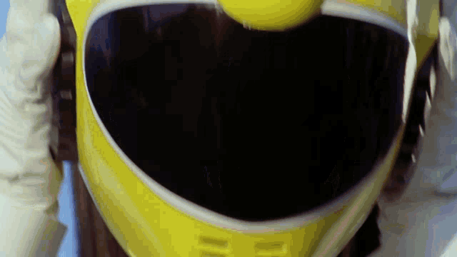 a close up of a person wearing a yellow helmet and gloves