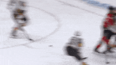 a blurry picture of a hockey game with a coca cola logo in the corner