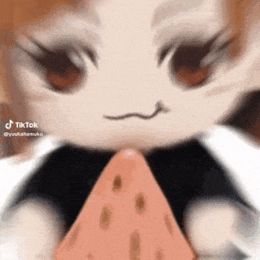 a close up of a stuffed animal holding a piece of strawberry .