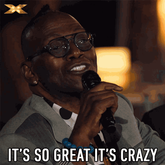 a man holding a microphone with the words it 's so great it 's crazy