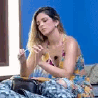 a woman in a floral dress is sitting on a bed with a blue wall .