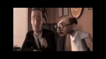 a man in a suit and tie is talking to another man with glasses and a mustache .