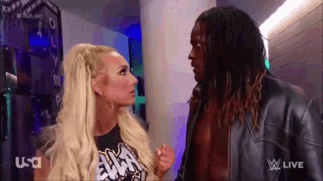 a man and a woman are standing next to each other on a wrestling show .