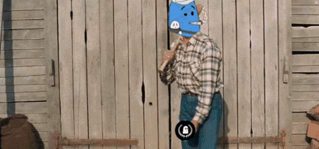a man in a plaid shirt has a blue face on his head