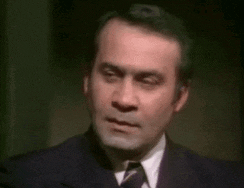 a man in a suit and tie is making a face .