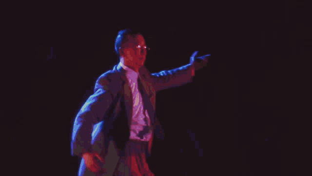 a man in a suit and tie is dancing on a stage