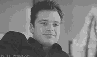 a man is smiling in a black and white photo .