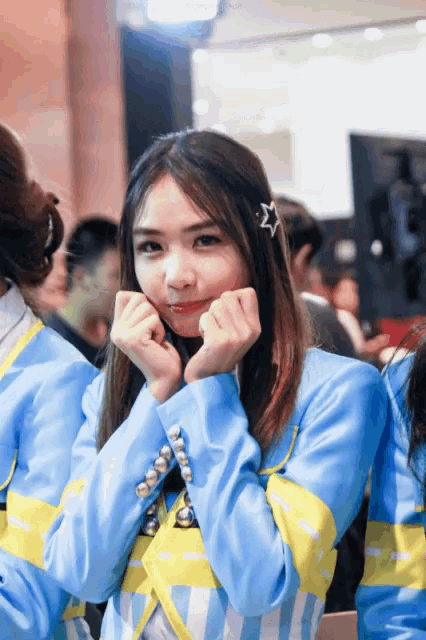 a girl with a star in her hair is wearing a blue and yellow striped jacket