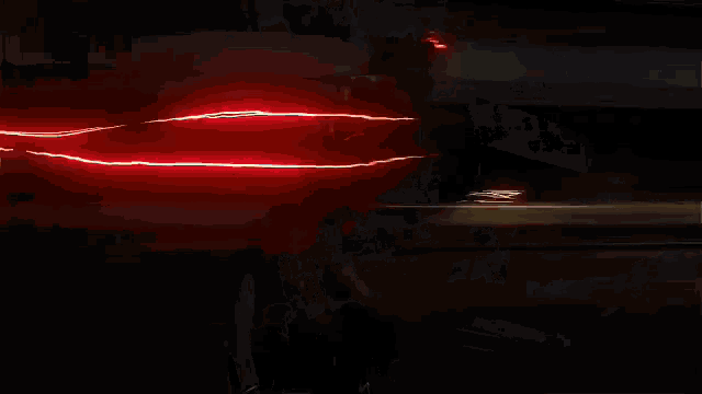 a person is being struck by a red lightning bolt in the dark