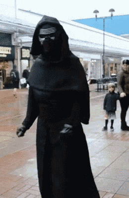 a person dressed as kylo ren walking down a sidewalk