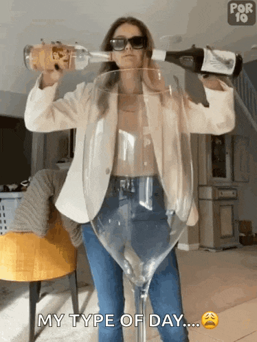 a woman is pouring a bottle of wine into a large wine glass ..