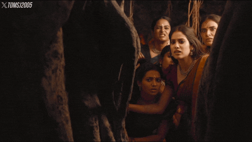 a group of women are standing next to each other in a dark room with xtoms / 2005 on the bottom