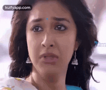 a close up of a woman 's face with a very sad look on her face .