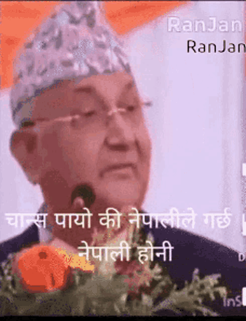 a man wearing glasses and a hat is giving a speech in a foreign language .