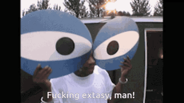 a man holding a pair of blue eyes with the words fucking ecstasy man on the bottom