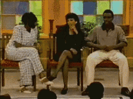 a group of people are sitting in chairs in front of a stained glass window