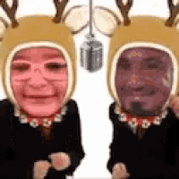 a man and a woman wearing reindeer hats with their faces on them .