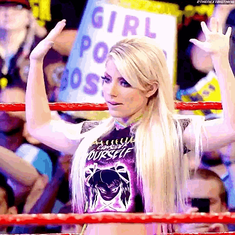 a woman in a wrestling ring with a sign that says girl power boss