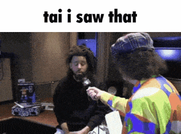 a man with dreadlocks is being interviewed by a clown