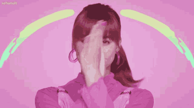 a woman covering her face with her hands in front of a pink background that says sehunult