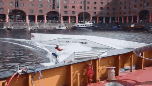a person riding a wave on a boat with red bull written on the side