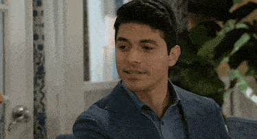 a man in a suit and blue shirt is smiling