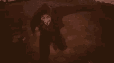 a man is standing in the dirt with blood on his pants and a gun in his hand .