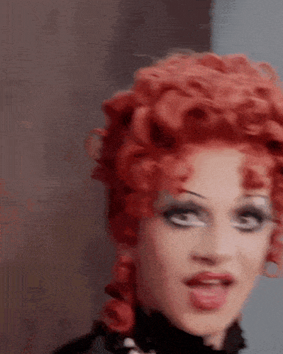 a close up of a woman 's face with red hair and makeup