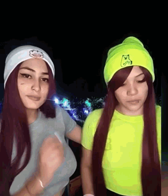 two women wearing beanies with a cat on them