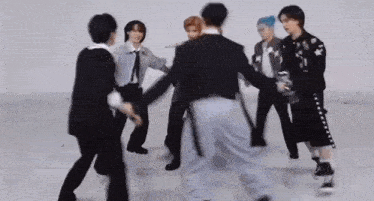 a group of young men are dancing together in a circle in a room .