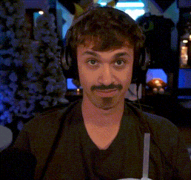 a man wearing headphones and a mustache is smiling
