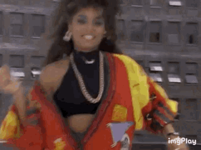 a woman is wearing a red and yellow jacket and a gold chain .