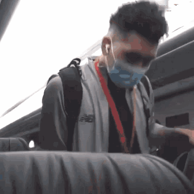 a man wearing a mask and a jacket that says new balance on the back