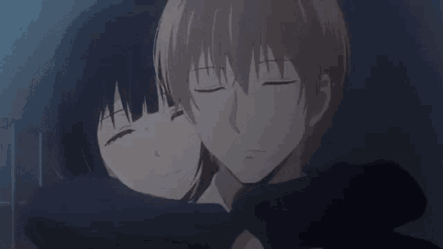 a boy and a girl are hugging each other in the dark .