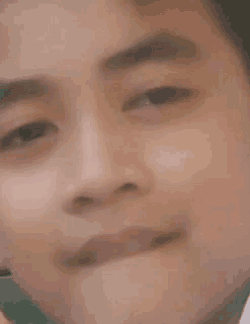 a close up of a young man 's face with his mouth open and his eyes closed .
