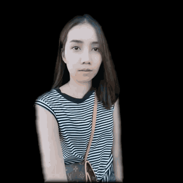 a woman wearing a black and white striped shirt has a louis vuitton purse on her shoulder