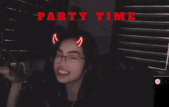 a girl with devil horns on her head is smiling in front of a screen that says party time