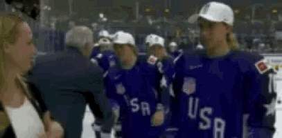 a woman is talking to a group of hockey players wearing usa uniforms